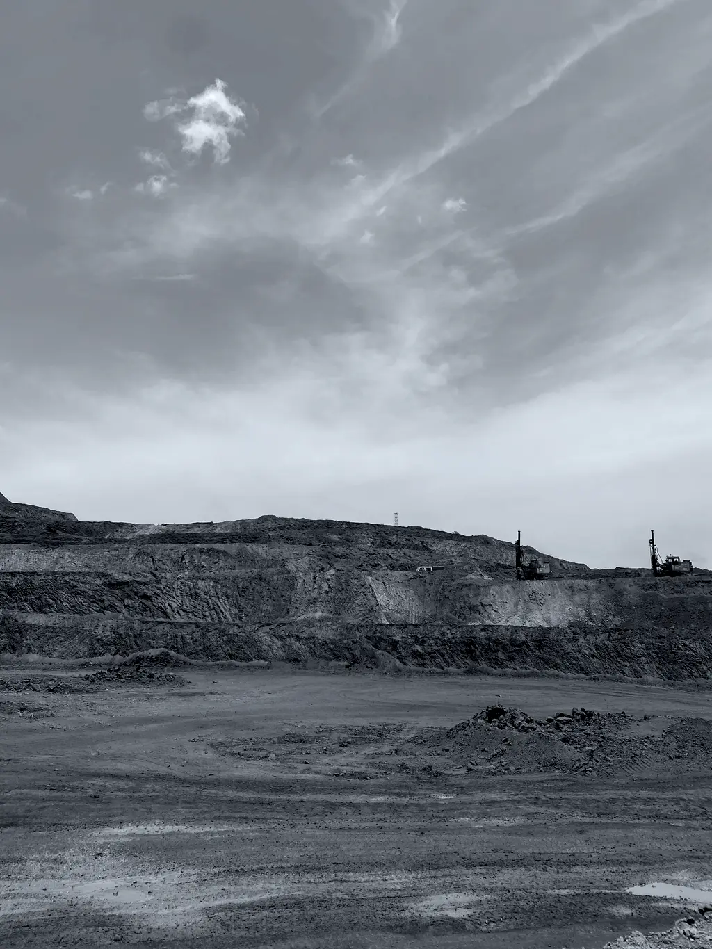 Open pit mine face with excavator working a bench